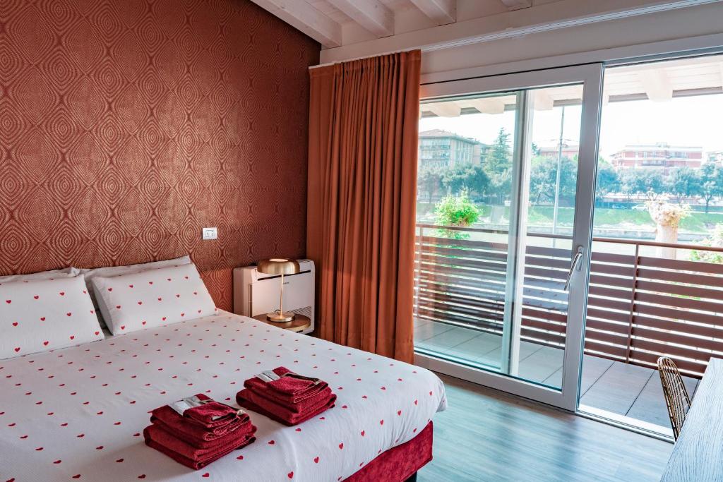 a bedroom with a bed with two red towels on it at Alla Riva in Verona