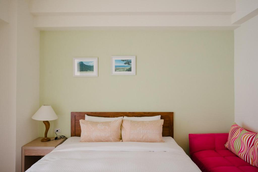 a bedroom with a bed and a red couch at He Sen B&B in Kenting
