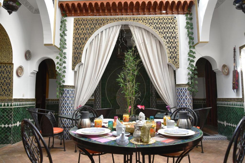a dining room with a table and chairs at Riad Assalam in Marrakech