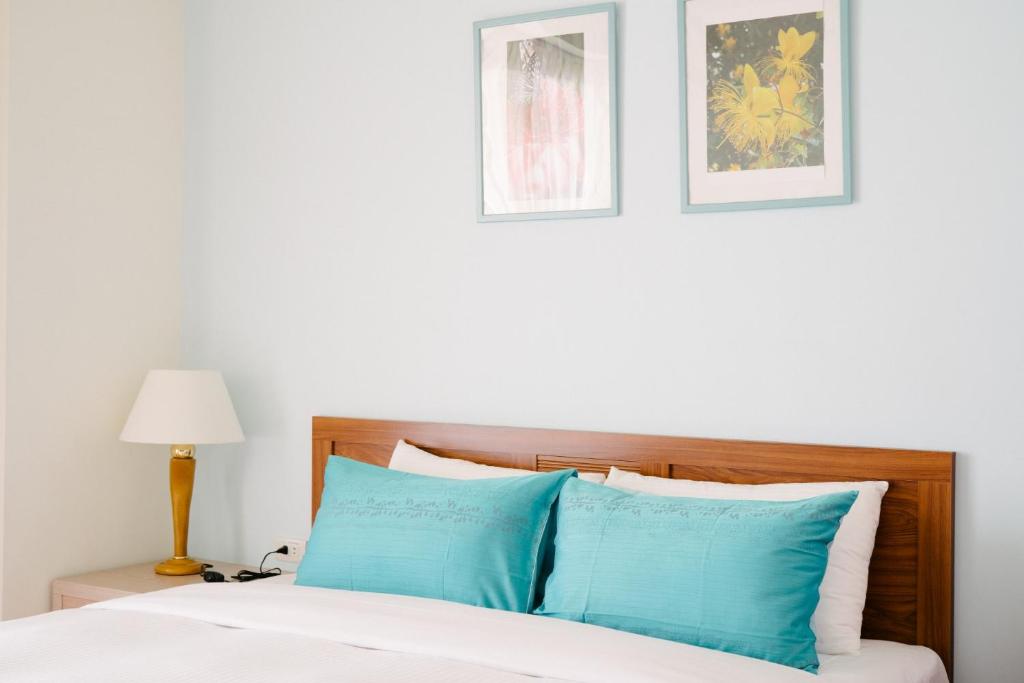 a bedroom with a bed with blue pillows at He Sen B&B in Kenting