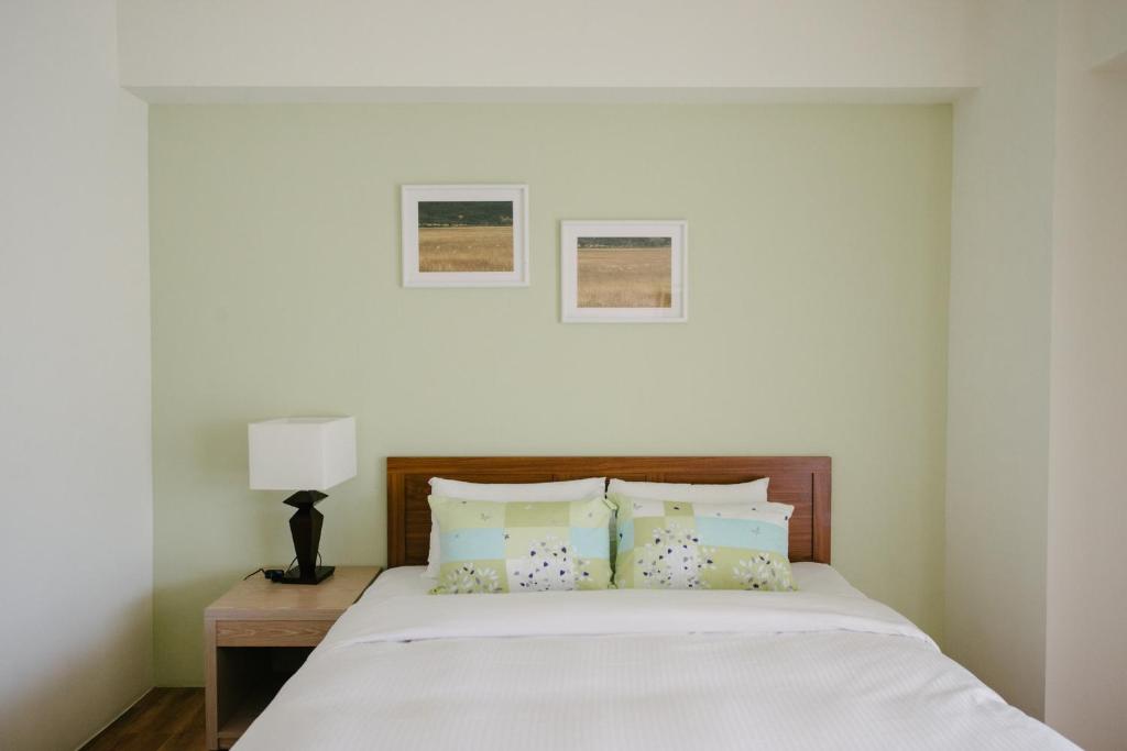a white bedroom with a bed with pillows at He Sen B&B in Kenting