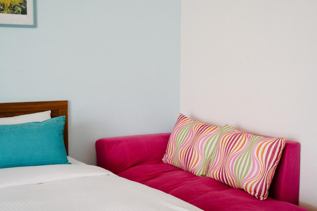 a room with a pink couch and a colorful pillow at He Sen B&B in Kenting