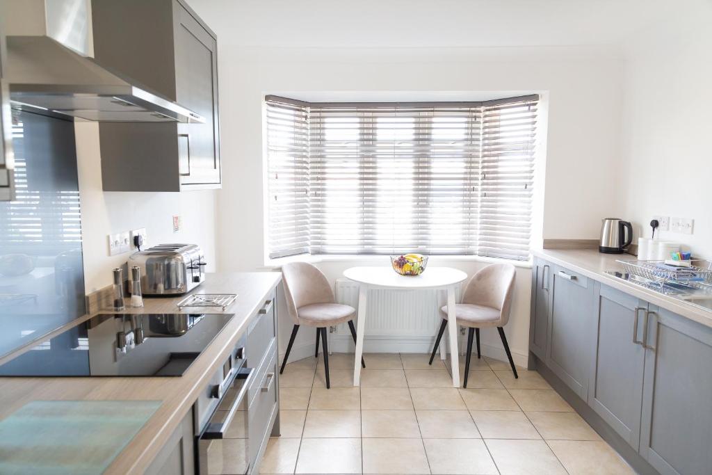 een witte keuken met een tafel en stoelen. bij Citystay - Franklin House in Cambridge