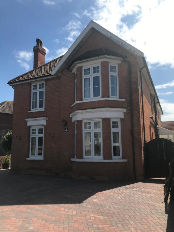 a brick house with white windows on a brick driveway at Thornbury Accommodation in Burnham on Sea