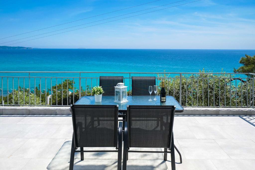 a table and chairs with a view of the ocean at Endless View Villa in Limenaria