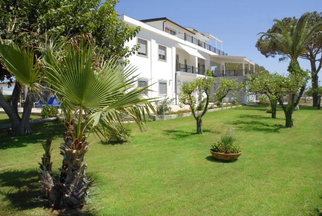 a palm tree in a yard in front of a building at Sikelika Residence Sul Mare in Scoglitti