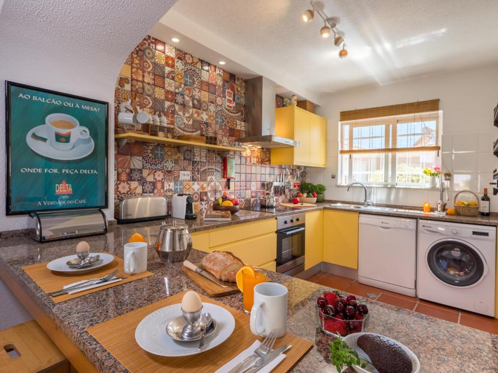 a kitchen with yellow cabinets and a counter top at Casa Cabrita - Surf & Family House in Sagres in Sagres