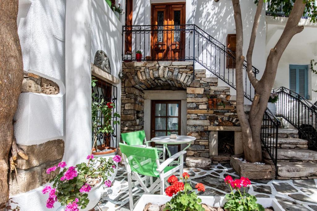 un patio con mesa, sillas y flores en Arco Naxos Luxury Apartments en Naxos