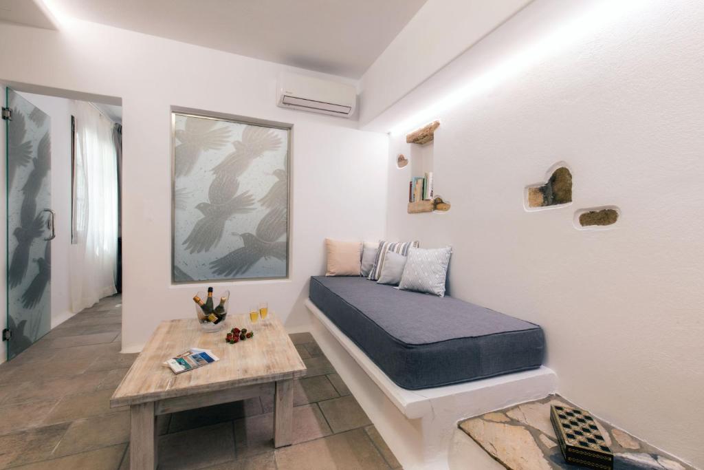 Arco Naxos Luxury Apartments في ناكسوس تشورا: غرفة نوم فيها سرير وطاولة فيها