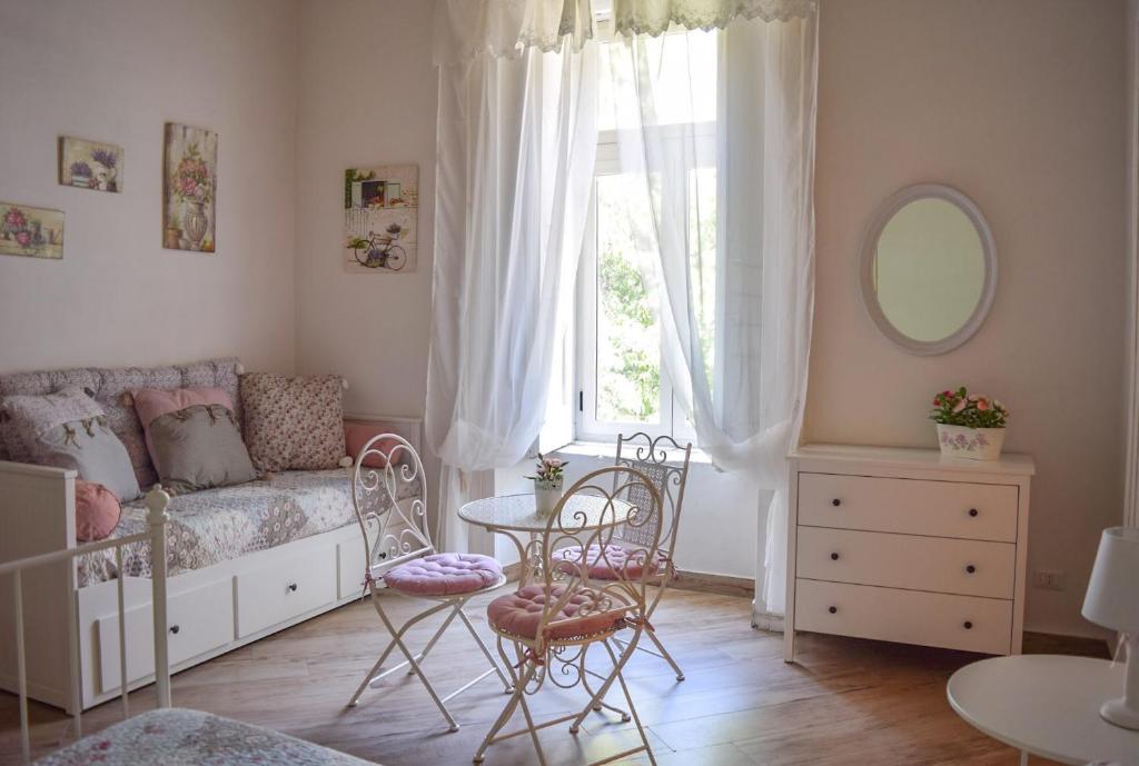 1 dormitorio con 1 cama, mesa y sillas en Maison la Mitra - Dimore Partenopee en Nápoles