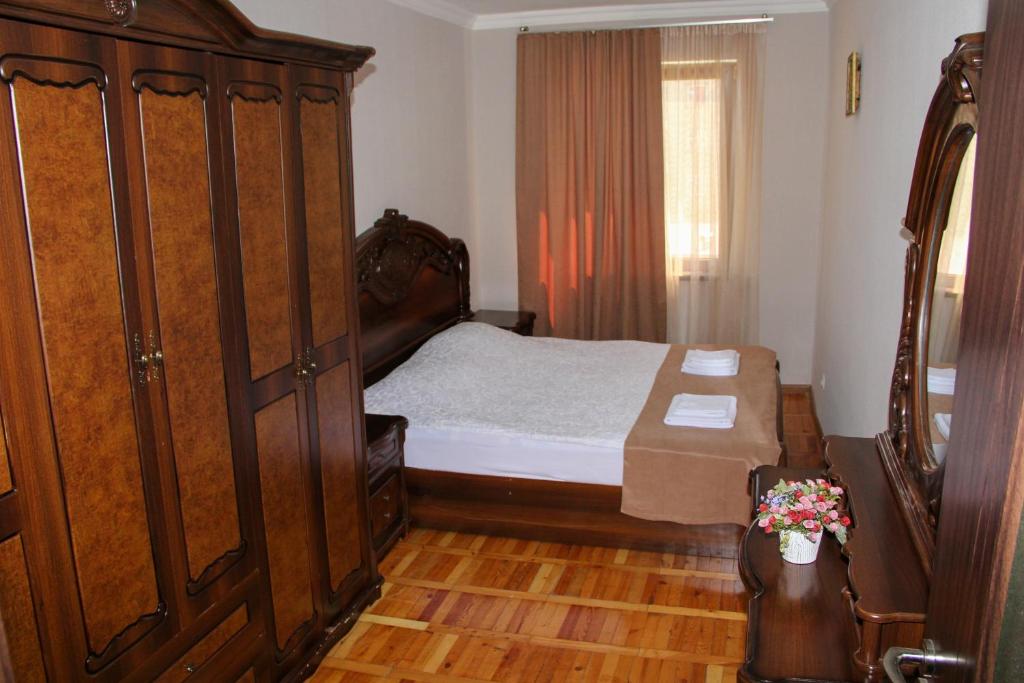 1 dormitorio con 1 cama y un gran armario de madera en Prometheus Apartment en Tskaltubo
