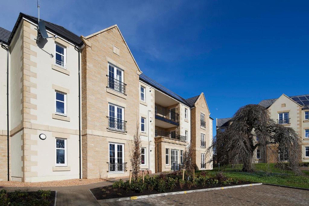 ein großes Backsteingebäude mit blauem Himmel im Hintergrund in der Unterkunft Royal Golf Apartments in Dornoch