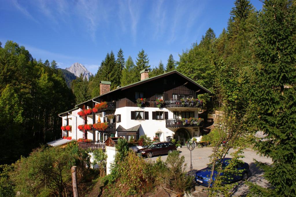 a large white building with a black roof at Gästehaus Lärchenhang in Mittenwald