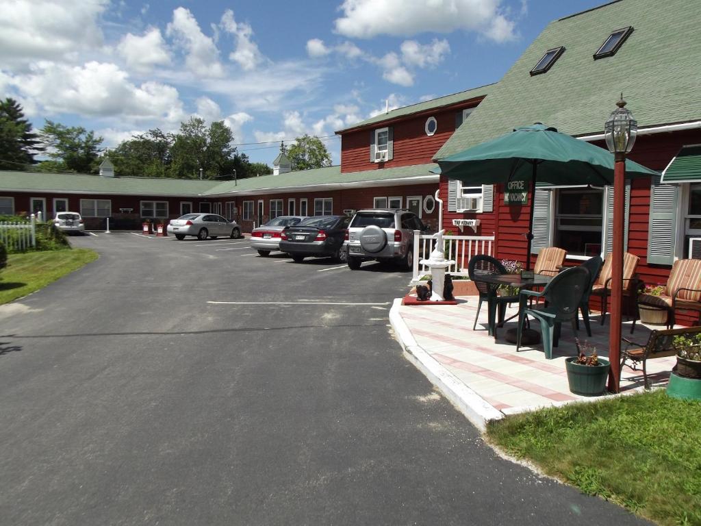 a parking lot with a table and an umbrella at Midway Lodging in Cornish