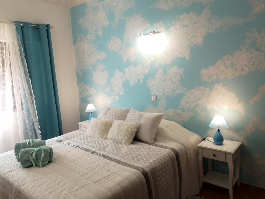 a bedroom with a bed with a blue wall at Nature Guesthouse in Lagos