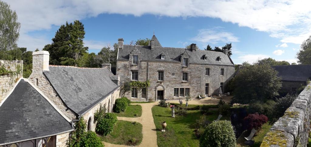 - une vue aérienne sur une grande maison en pierre avec une cour dans l'établissement Manoir du Moustoir - Hôtel Les Empreintes, à Saint-Évarzec