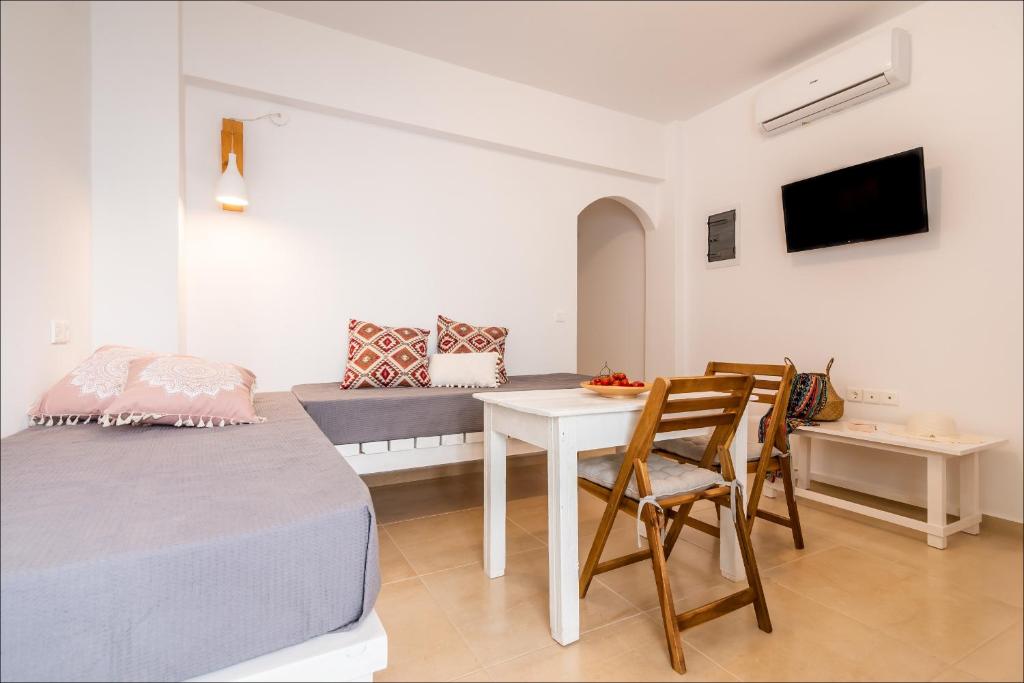 Zimmer mit einem Bett, einem Tisch und Stühlen in der Unterkunft Krystalia's Apartment in Plaka Milos