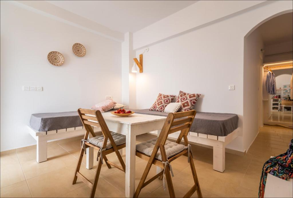 a dining room with a table and chairs and a couch at Krystalia's Apartment in Plaka Milou