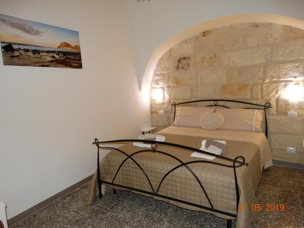 a bedroom with a bed with a stone wall at La Casetta di Ninella in Polignano a Mare