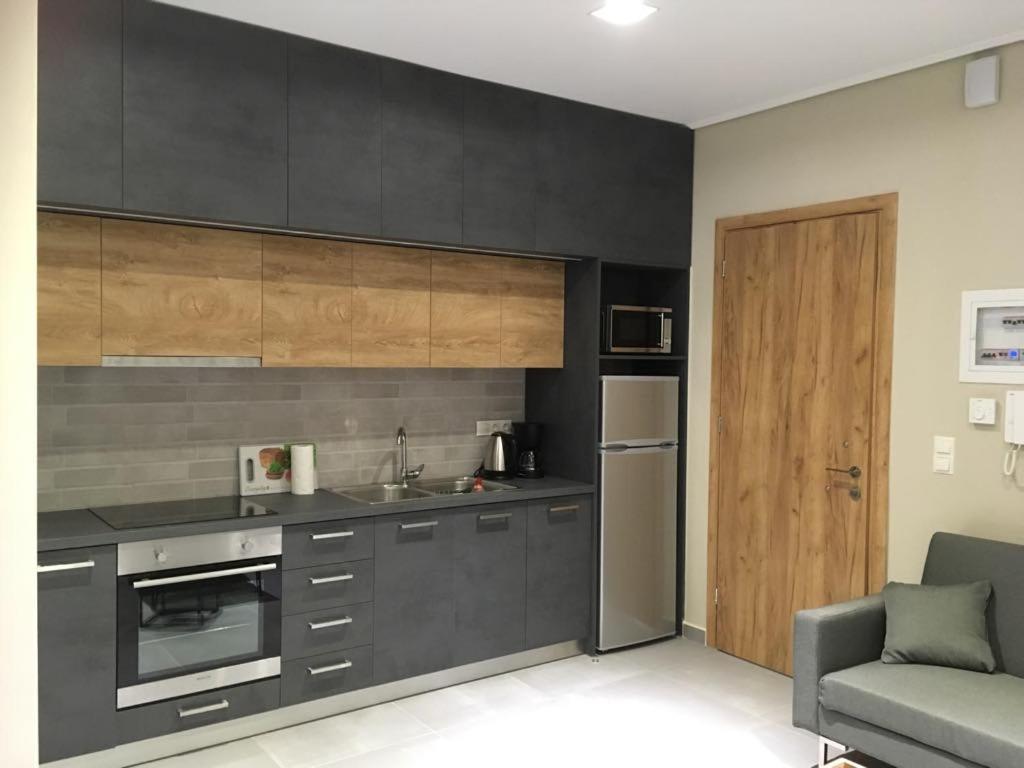 a kitchen with black cabinets and a refrigerator at Sofie's Choice Mytilini in Mytilene