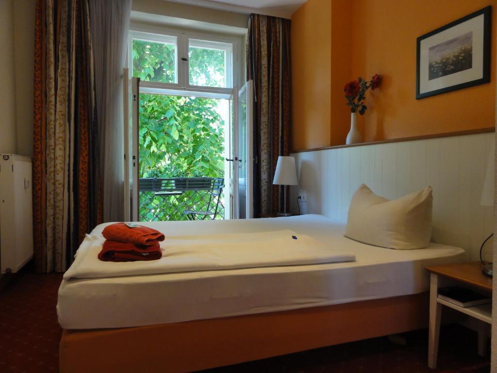 a hotel room with a bed with a window at Pension Zeitlos in Potsdam