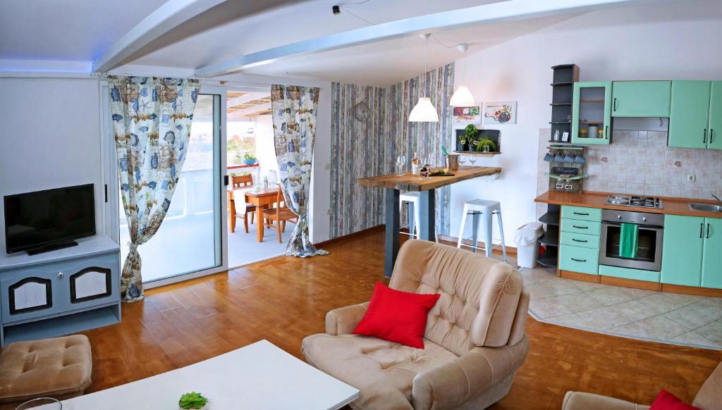 uma sala de estar com um sofá e uma cozinha em Apartman Capitano Vrsi em Vrsi