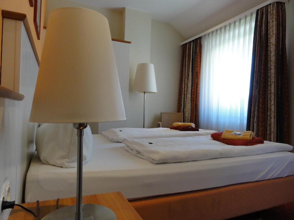a bedroom with a bed with a lamp and a window at Pension Zeitlos in Potsdam