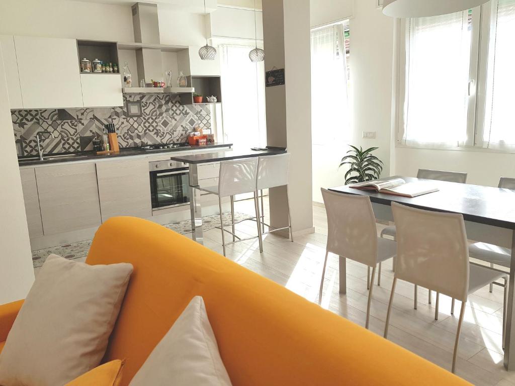 a living room with a yellow couch and a kitchen at Appartamento La Casetta in Arona