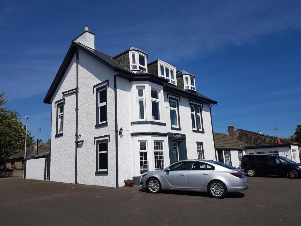 a silver car parked in front of a white house at Seaview Wellness Retreat and Guesthouse in Carnoustie
