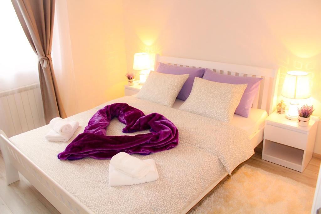 a white bed with a purple blanket on it at Sweet Dreams in Plitvička Jezera