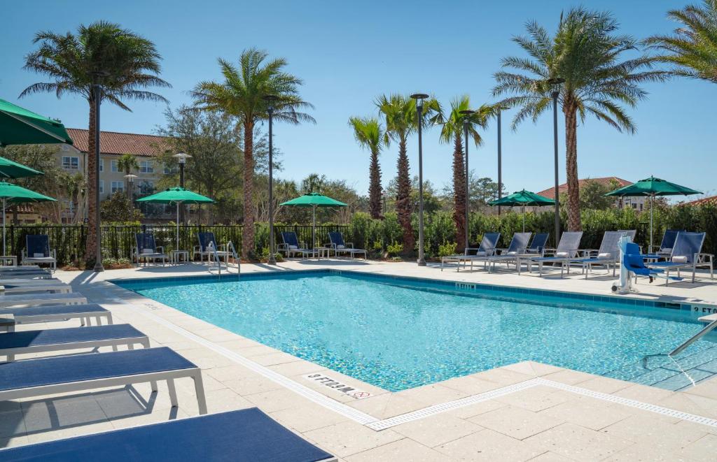 una piscina con sillas y sombrillas en un complejo en Hyatt Place Sandestin at Grand Blvd, en Destin