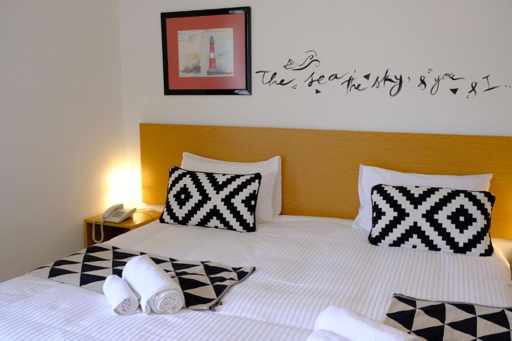 a bedroom with a bed with black and white pillows at Hotel Wakim in Broummana