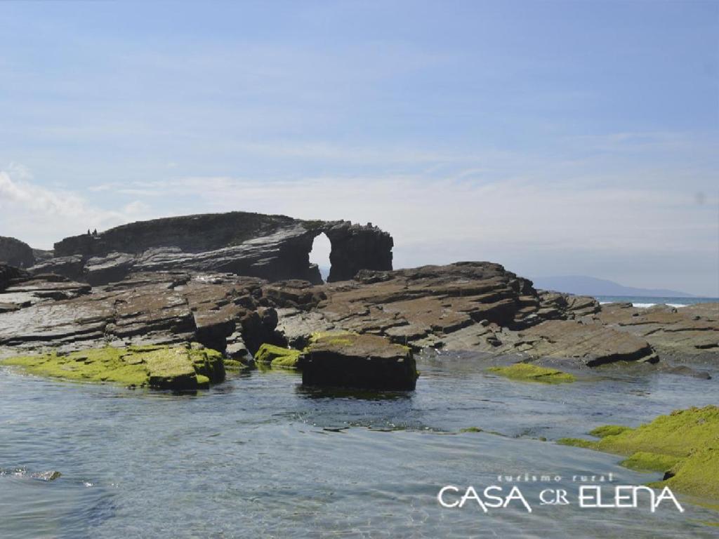a waterfall on a rocky island in the ocean at Casa Elena Turismo Rural in Reinante