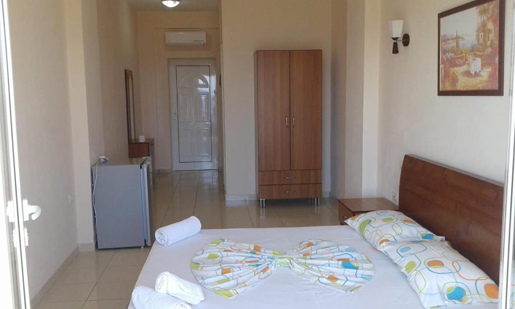 een slaapkamer met een bed en een koelkast bij Oasis Drymades Hotel in Dhërmi