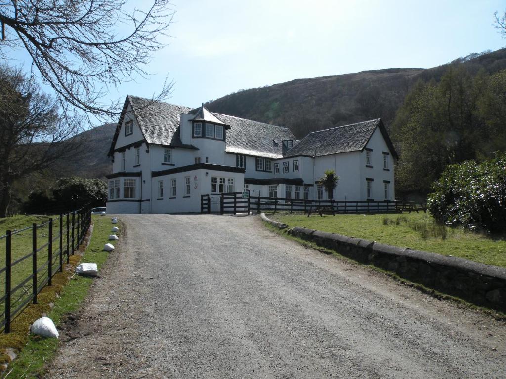 una grande casa bianca sul ciglio di una strada di Lochranza Youth Hostel a Lochranza