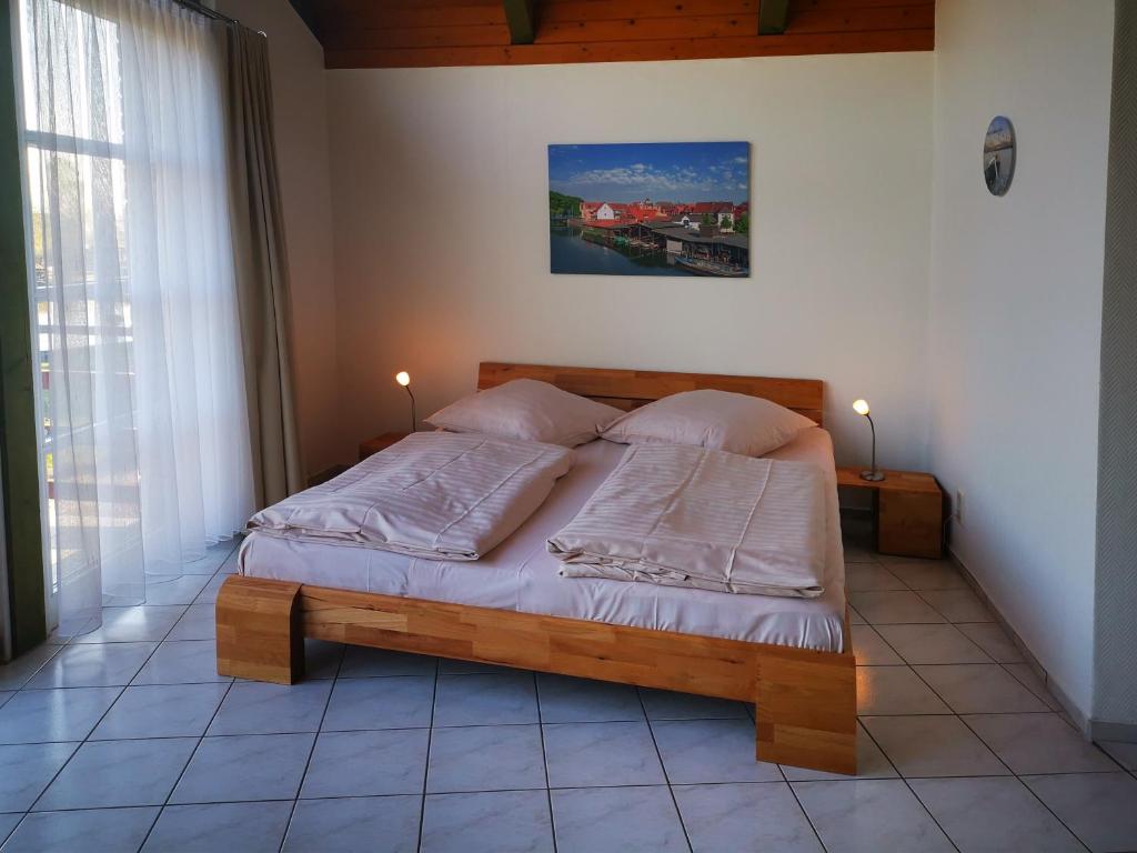 um quarto com uma cama de madeira e 2 almofadas em 1-Zimmer-Ferienwohnung em Plau am See