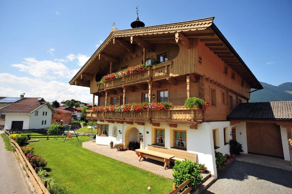 uma casa de madeira com um banco em frente em Maurerhof Itter em Itter