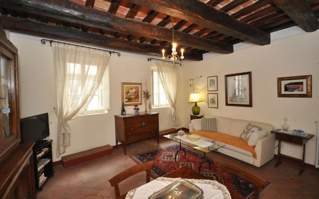 uma sala de estar com um sofá e uma televisão em Appartamento Il Loggiato em Cortona
