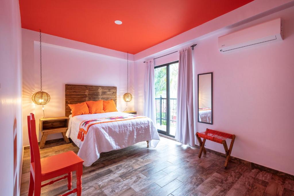 a bedroom with a bed with an orange ceiling at Hotel Boutique Santa Lucía in Aquismón