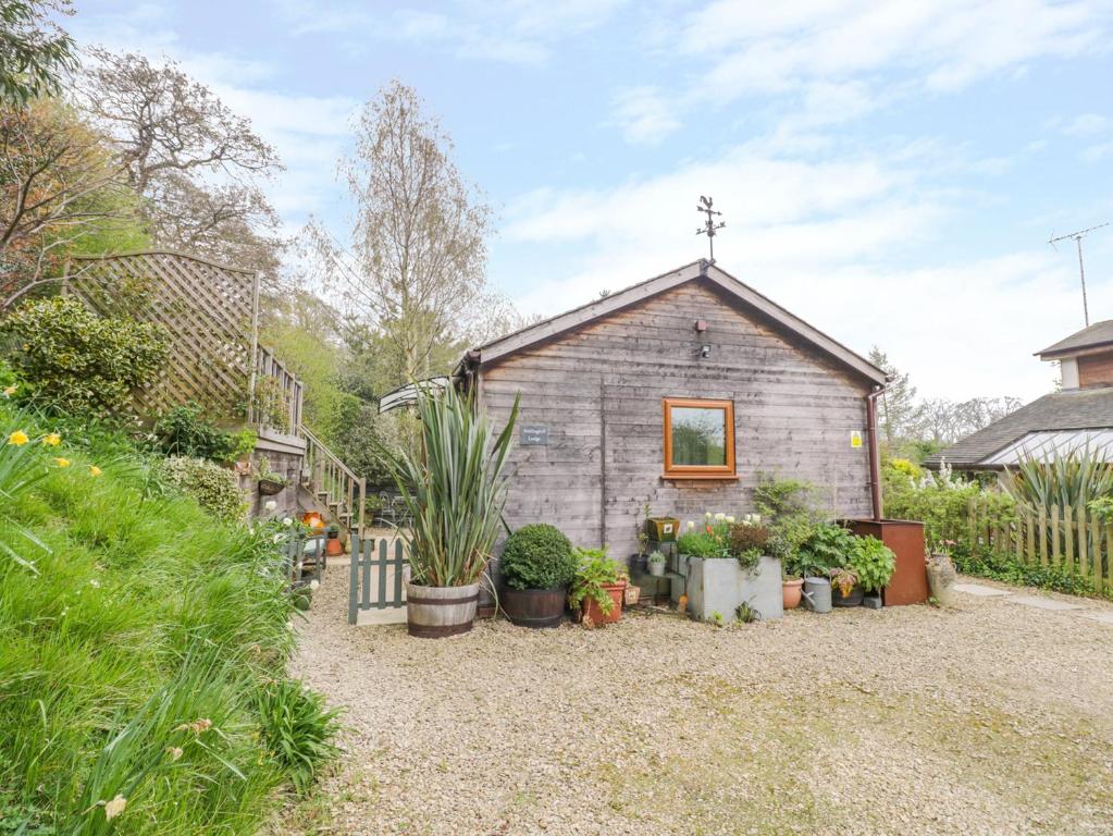 a small house with plants in front of it at Wellinghill Lodge in Cheltenham