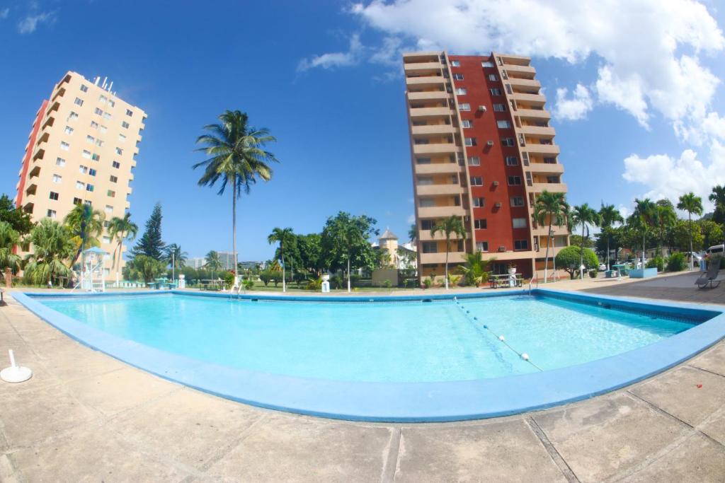 an empty swimming pool in the middle of two buildings at Surf Turf Two Bedroom Suite At Turtle Towers in Ocho Rios