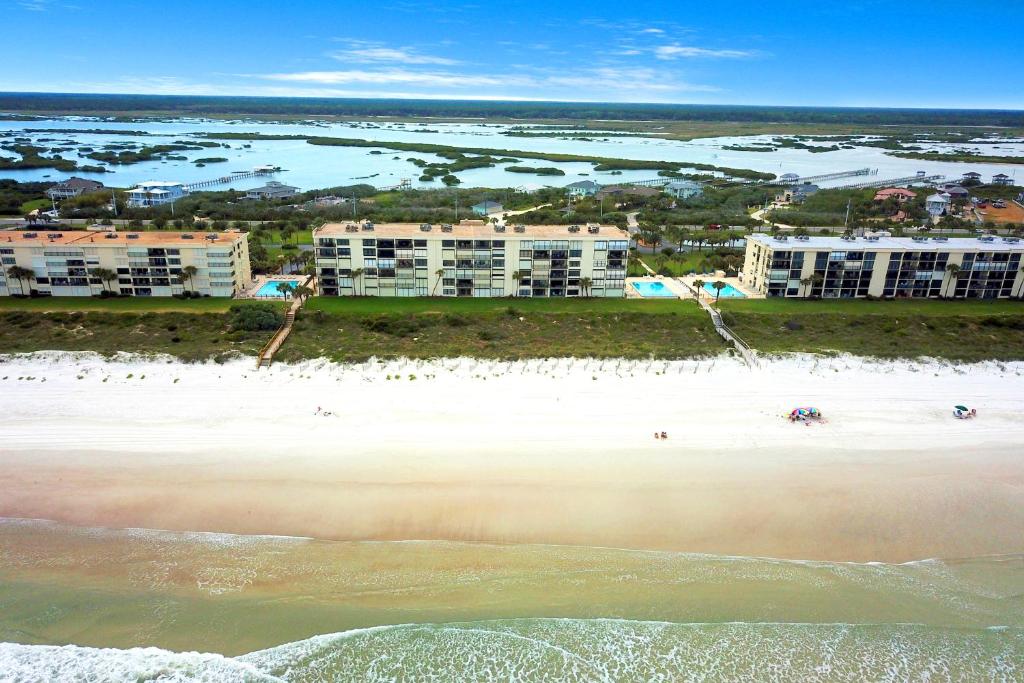 eine Luftansicht auf einen Strand mit Gebäuden im Hintergrund in der Unterkunft Sand Dollar in Cedar Landing