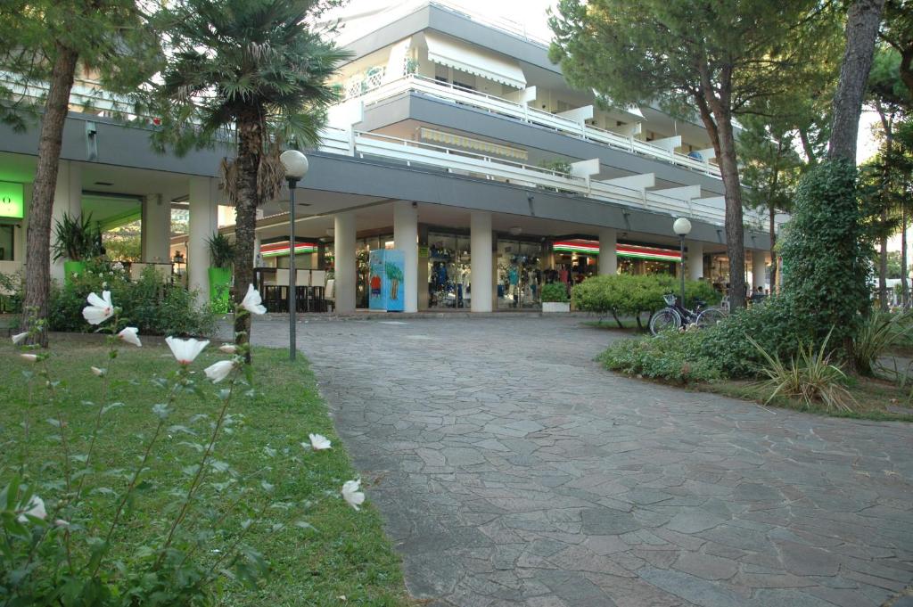 a large building with a walkway in front of it at Residence Isvico in Lignano Sabbiadoro