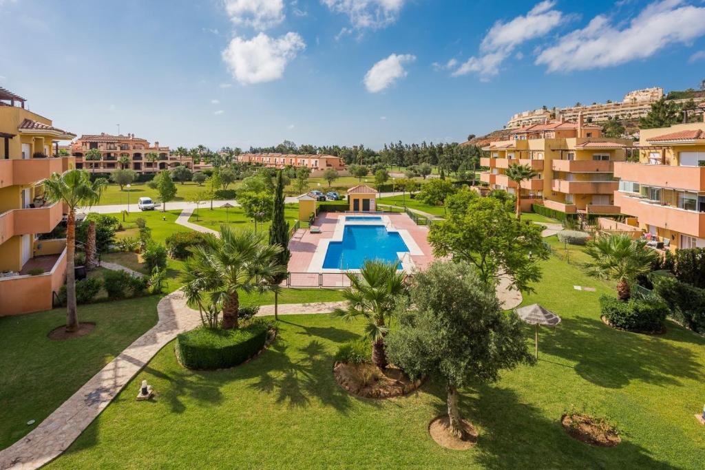an aerial view of a resort with a swimming pool and palm trees at Wonderful apartment 5 minutes flat walk to the Centre of La Cala de Mijas in La Cala de Mijas