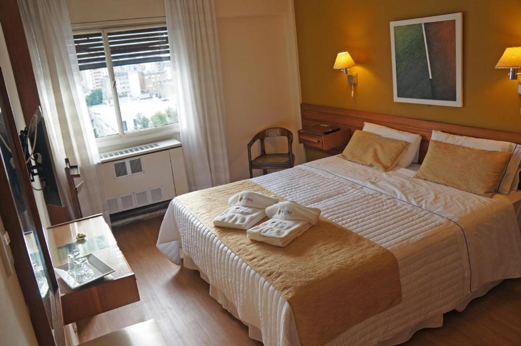 1 dormitorio con 1 cama con 2 toallas en Hotel Sussex en Córdoba