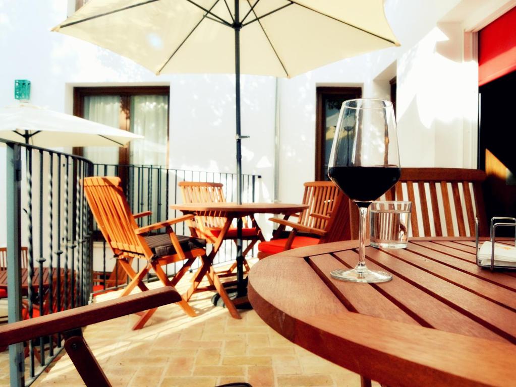 una copa de vino en una mesa de madera en La Posada de Quijada, en Granada