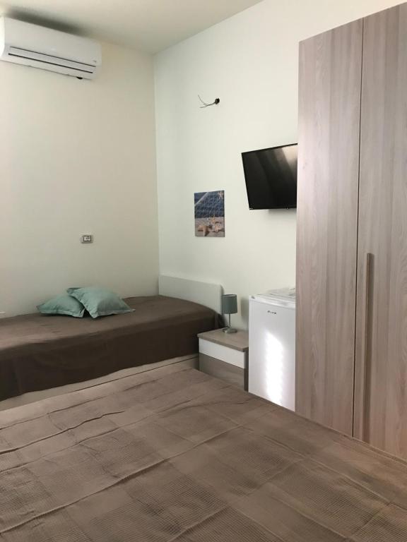 sypialnia z łóżkiem i telewizorem z płaskim ekranem w obiekcie B&B Stella del Mare w mieście Lampedusa