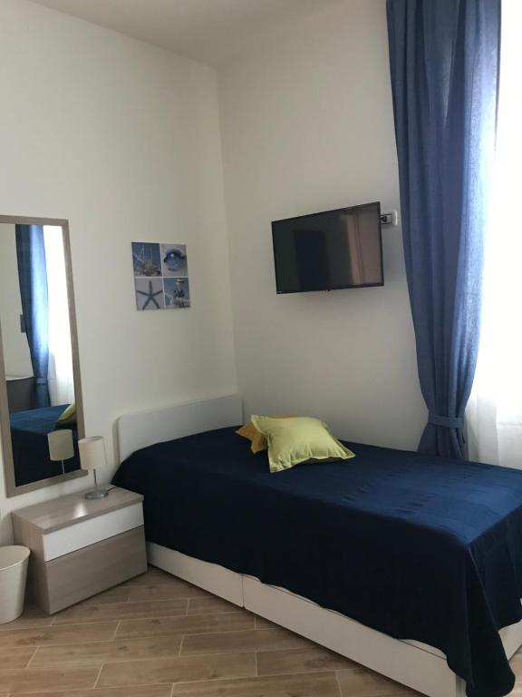 sypialnia z łóżkiem i telewizorem na ścianie w obiekcie B&B Stella del Mare w mieście Lampedusa