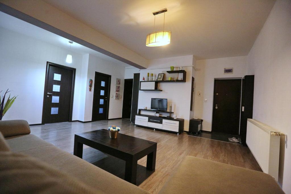 uma sala de estar com um sofá e uma mesa de centro em Bloc Izvor em Piteşti