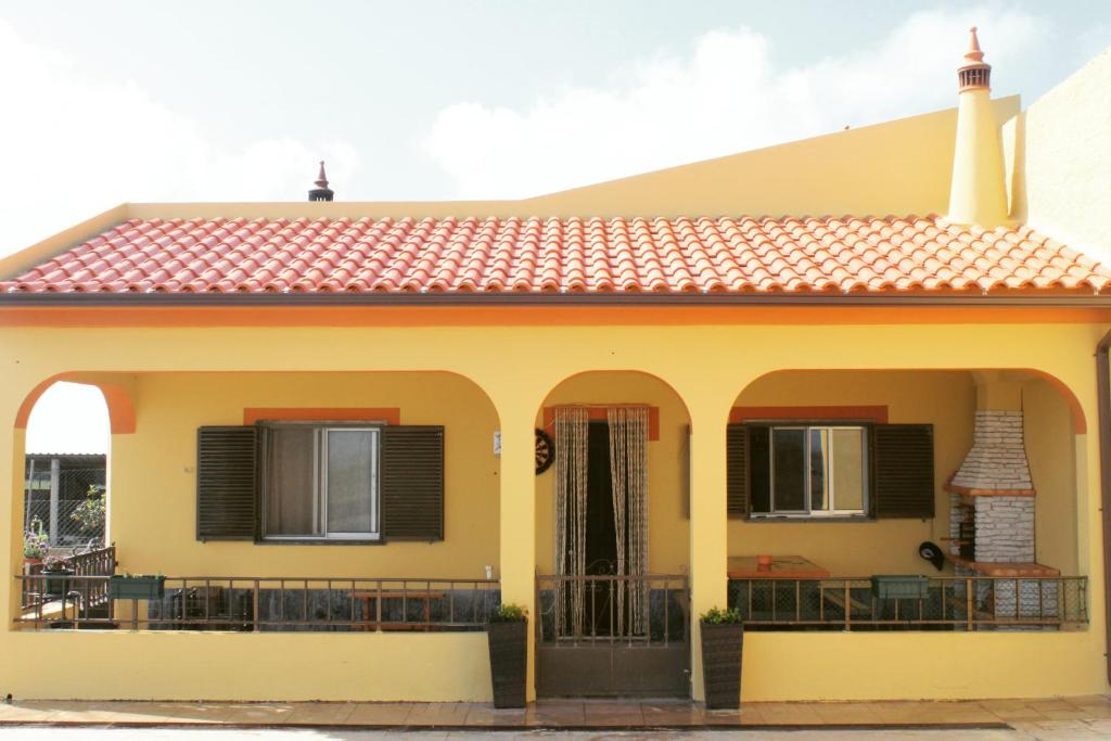 uma casa amarela com um telhado vermelho em Abrigo das Nortadas em Vila do Bispo